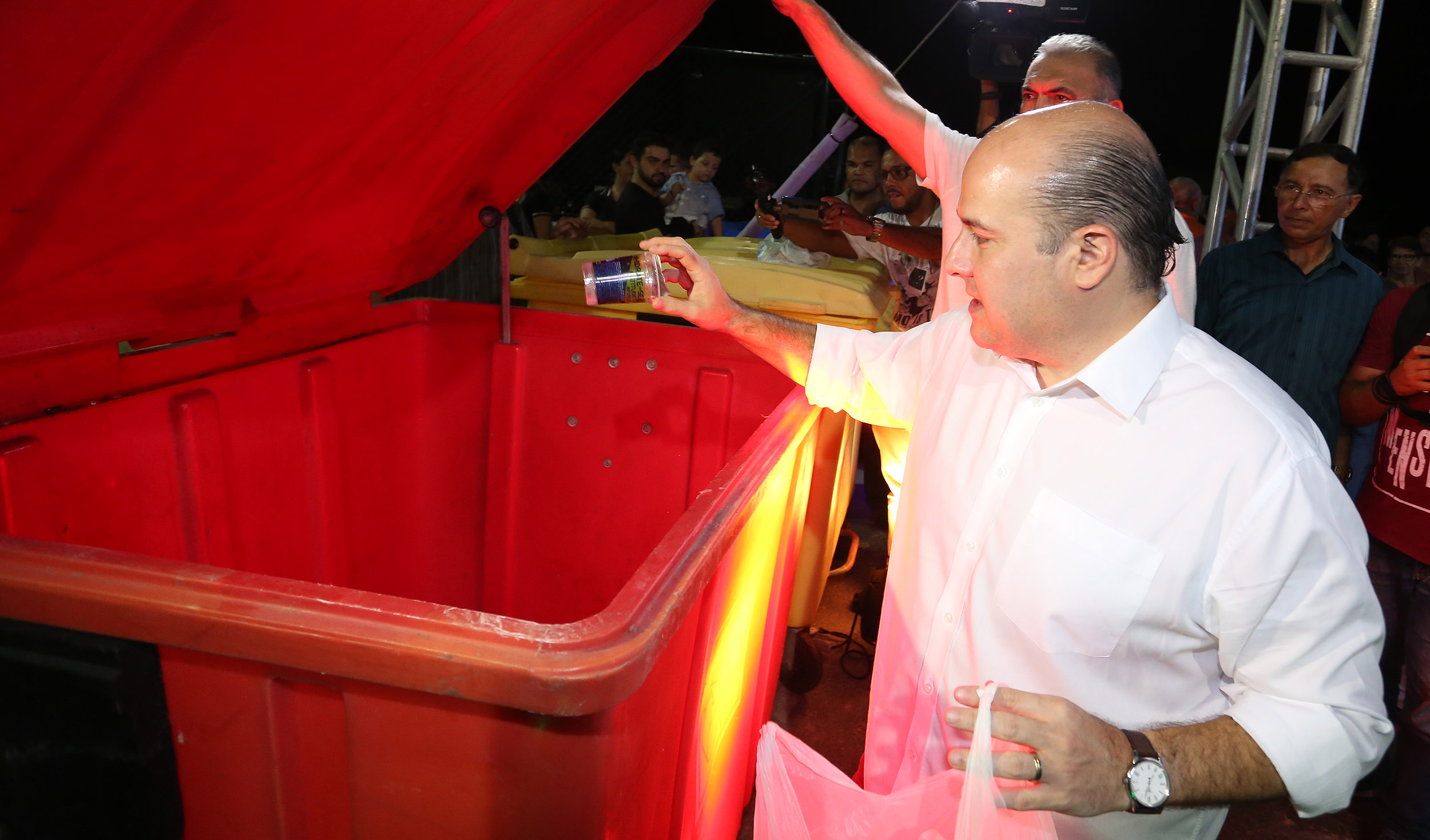 prefeito roberto cláudio joga um copo plástico dentro de uma caçamba